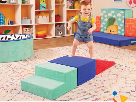 Child playing with colorful foam blocks in a playroom setting